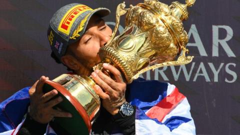 Lewis Hamilton kisses the trophy after winning the British Grand Prix