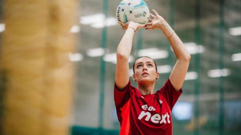 Nottingham Forest netball player shoots for goal.