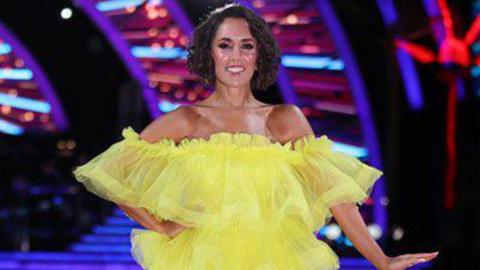 Janette Manrara in a yellow dress on the set of strictly come dancing.