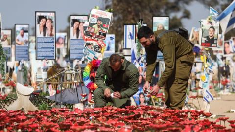 Israeli soldiers light candles at a memorial site for the victims of the Hamas attack at the Supernova music festival on 7 October 2023, near Kibbutz Reim, southern Israel (31 January 2025)