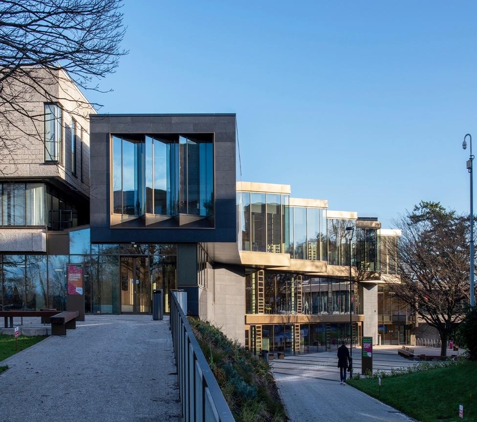 Campus Central is a sandstone and glass building bordering a tree lined pedestrian plaza.