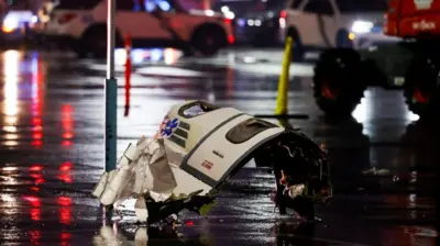 A part of the wrecked plane is seen on the ground where the crash happened in Philadelphia