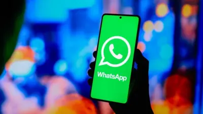 Photo of hand wey hold phone wit WhatsApp on di screen