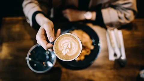 A cup of coffee next to some croissants (Credit: Getty Images)