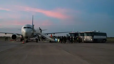 Getty Images Migrants boarding a deportation flight to Venezuela in October 2023