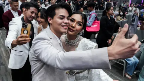 A same-sex couple poses for pictures at a marriage registration event at Paragon shopping mall in Bangkok on January 23, 2025. 