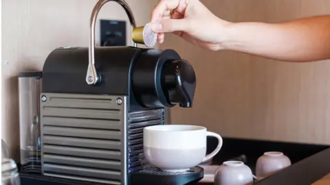 Getty Images A person making a cup of coffee using a coffee capsule