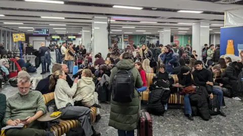 A crowd of passengers at Edinburgh Airport