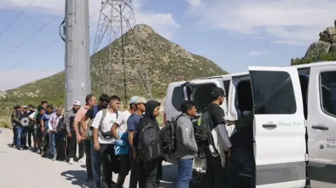 Getty Images Migrants being processed at the US-Mexico border on 9 June