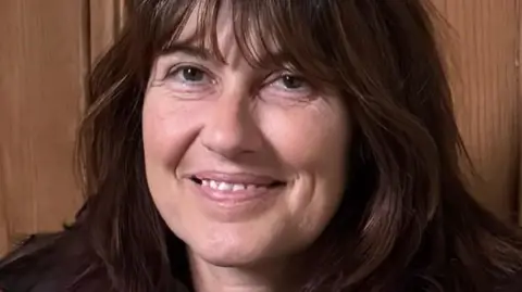 Dawn Page A woman with brown hair smiling at the camera