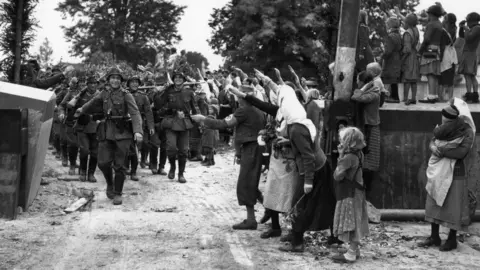 Getty Images Wehrmacht soldiers entering Czechoslovakia in 1938 as locals salute