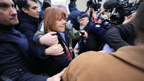 Gisèle Pelicot in a crowd of journalists 