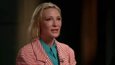 Cate Blanchett wearing a red and while striped jacket 