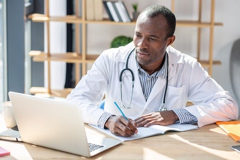 Rural Health Disparities. A doctor on his computer speaks with a patient via a telehealth app.