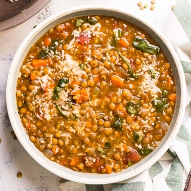 instant pot lentil soup in a bowl with garnish