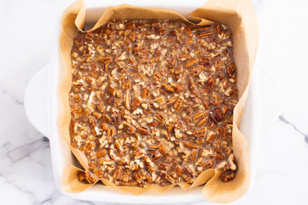 Unbaked healthy pecan pie bars in baking dish.