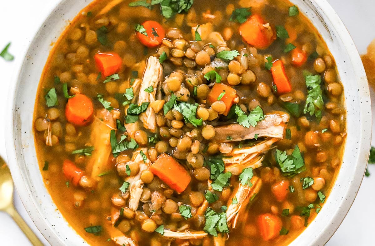 Closeup of lentil soup with shredded chicken, lentils and carrots in a bowl.