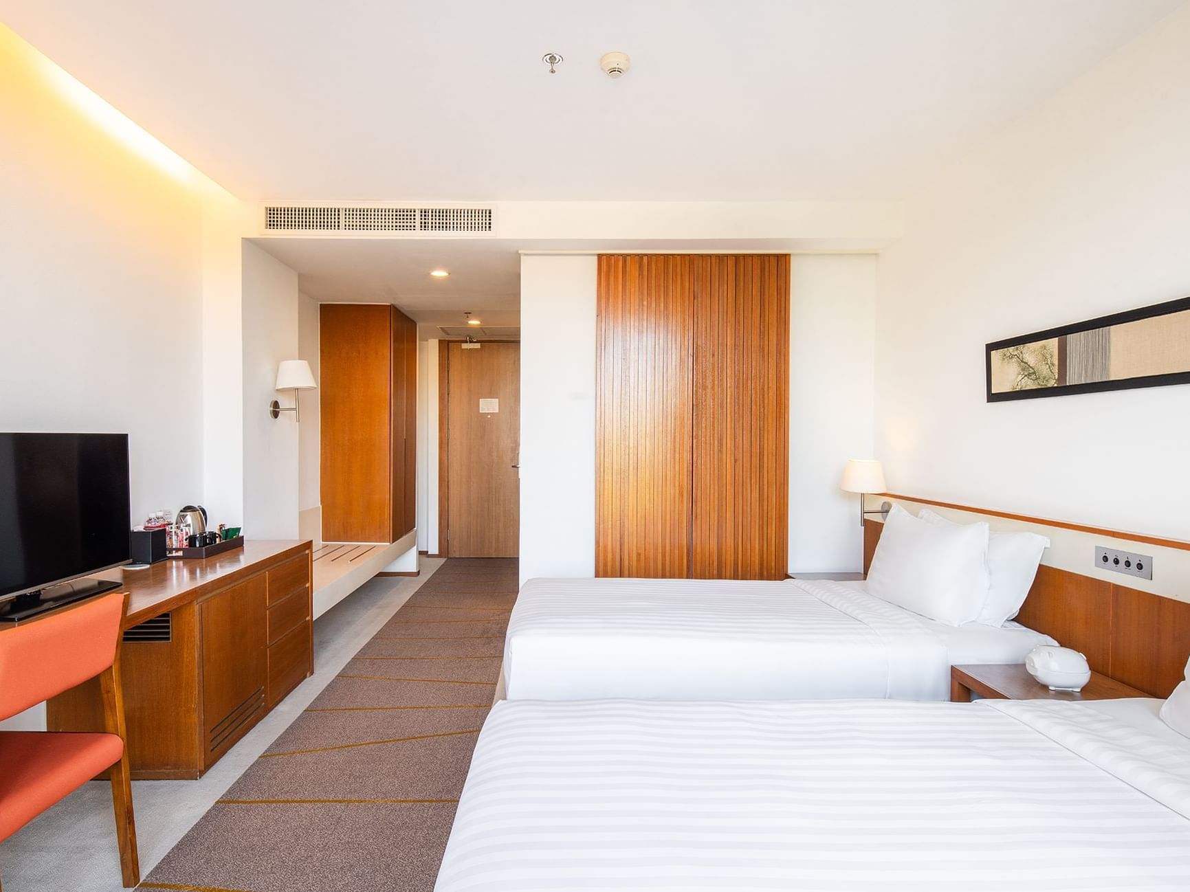 Two beds with television in Superior Room at Eastin Tan Hotel Chiang Mai