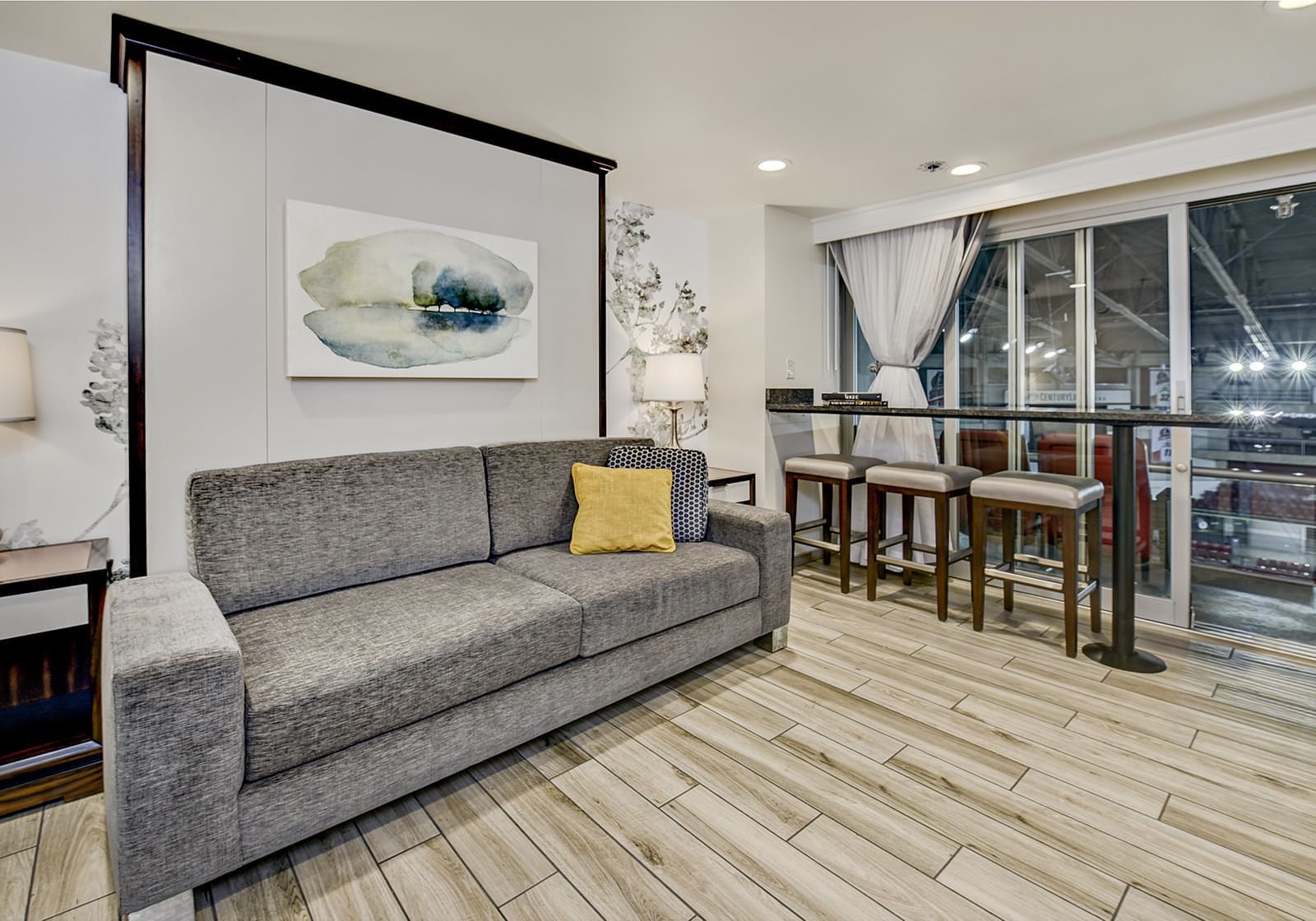 Couch, breakfast bar and balcony of living room in Arena room at The Grove Hotel