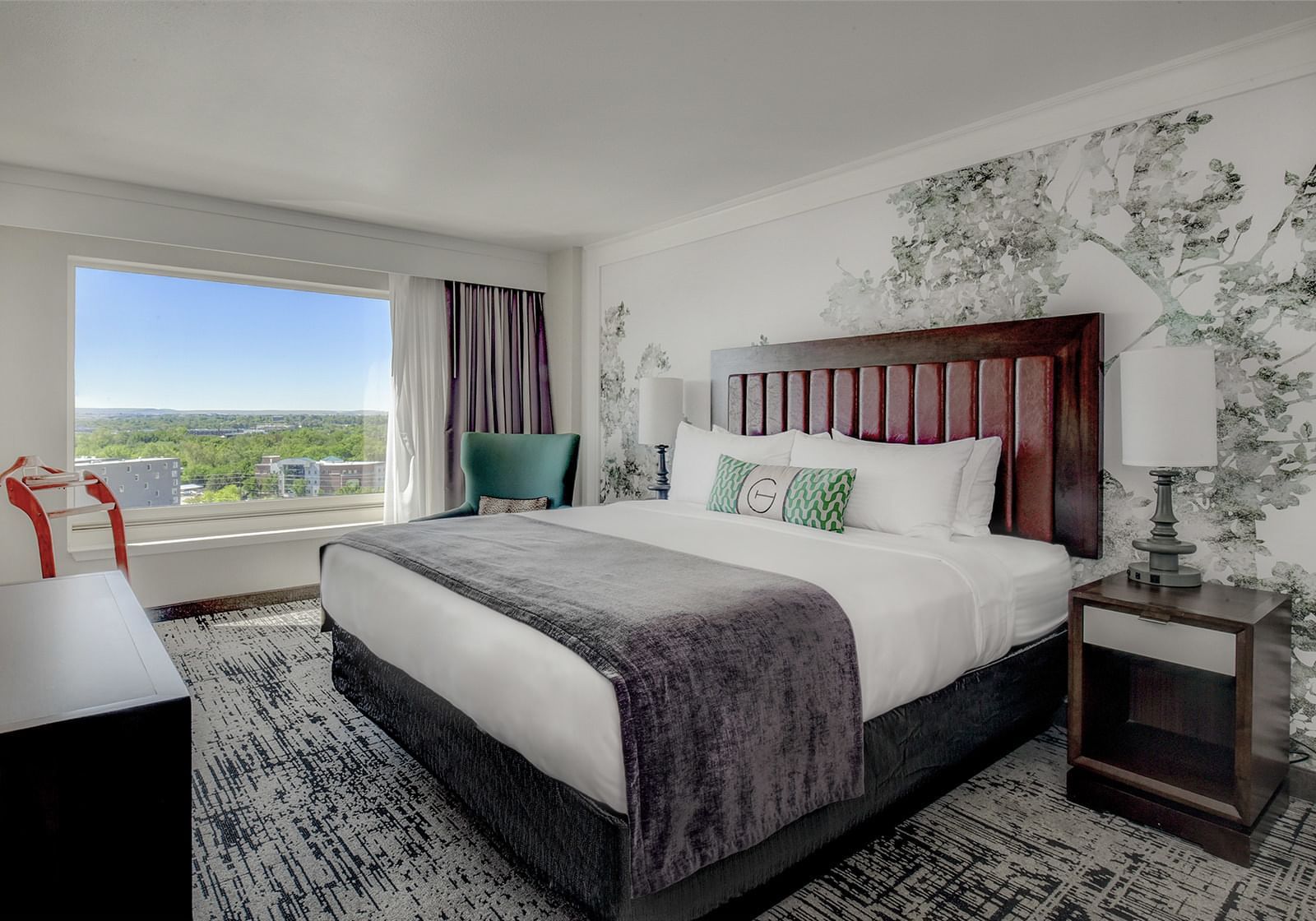 Comfy bed and work desk in the King Deluxe bedroom at The Grove Hotel