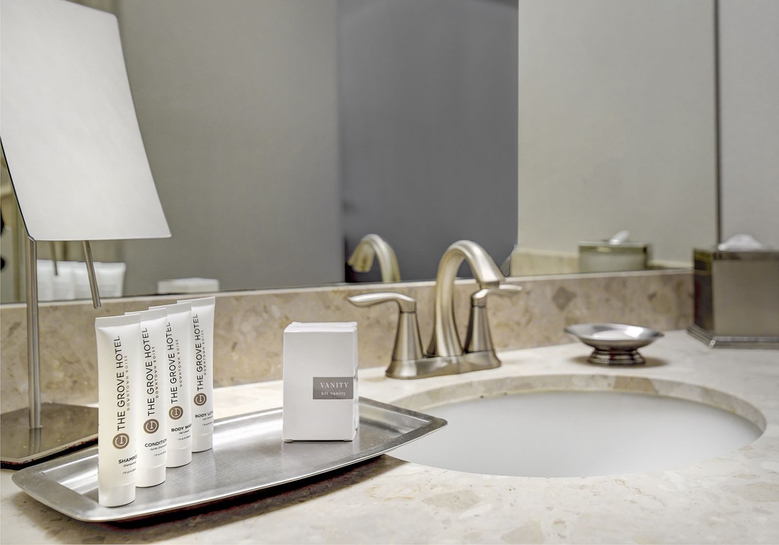 Bathroom countertop with sink, faucet, and toiletries at The Grove Hotel