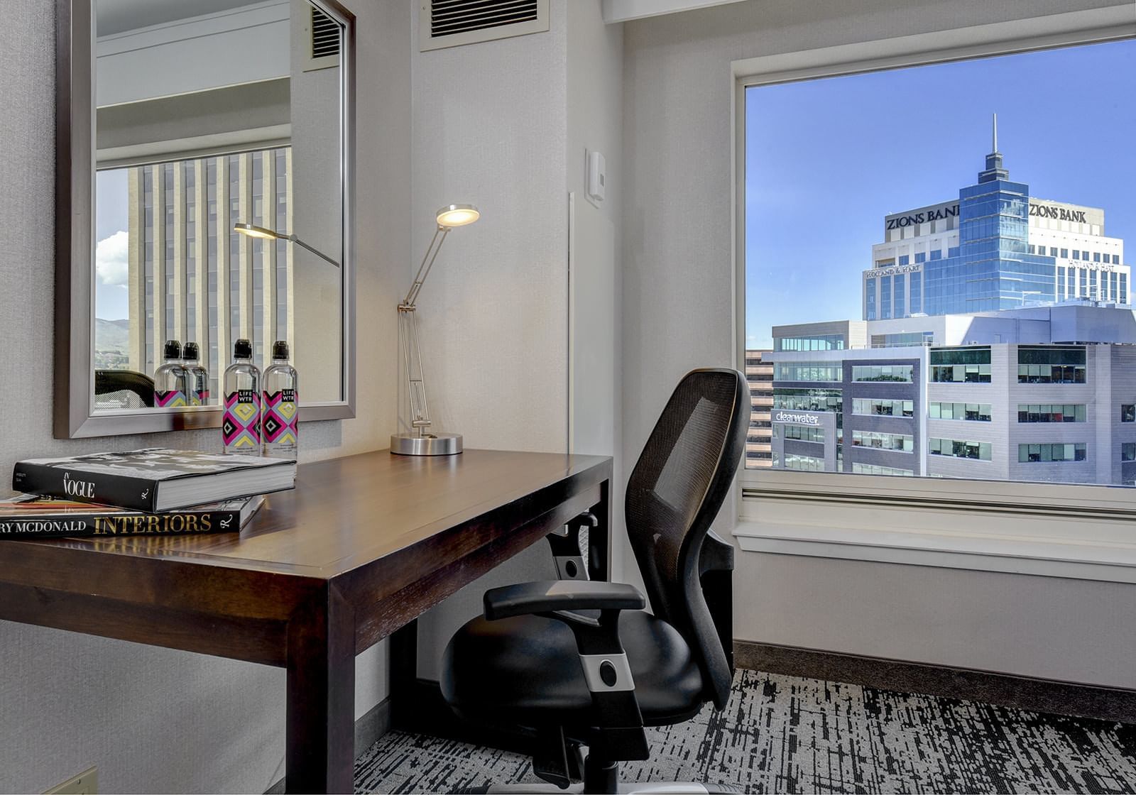 Chair & a desk in a room with the city view at The Grove Hotel