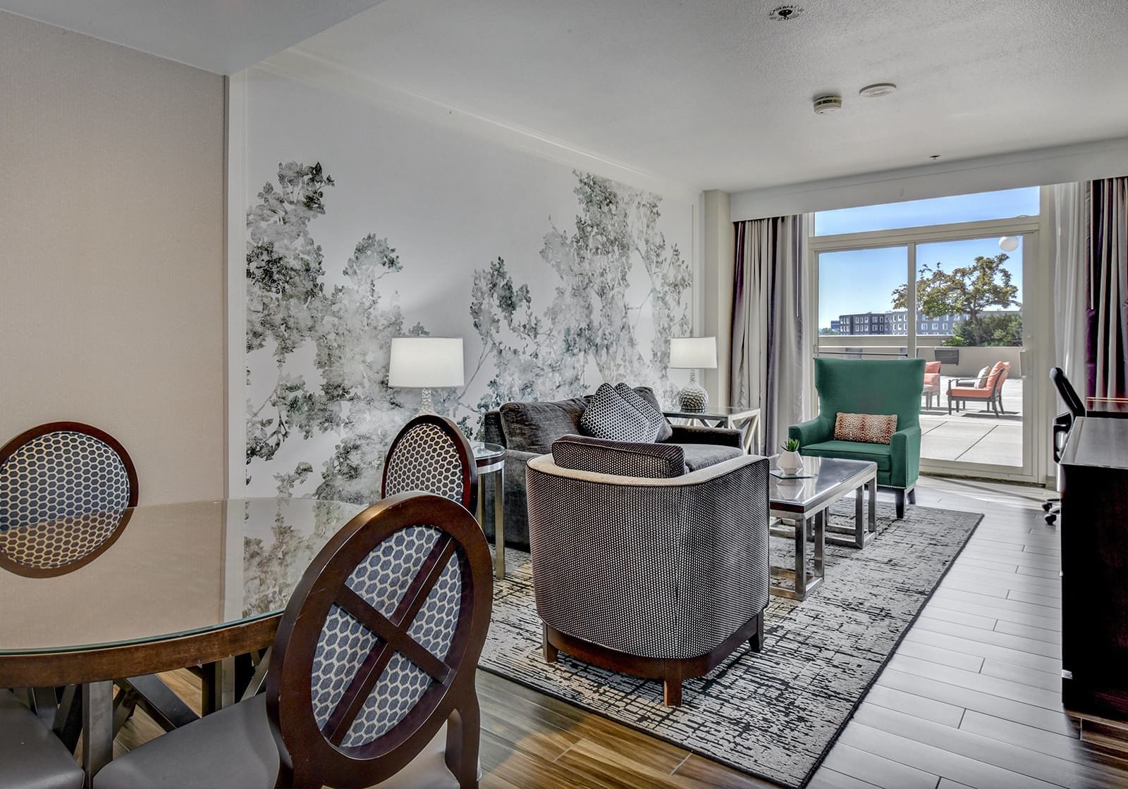 Table and comfy chairs in a living area in King Grand Suite at The Grove Hotel