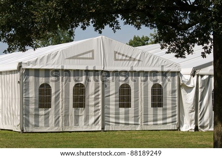 A white party or event tent on a meadow in a public park