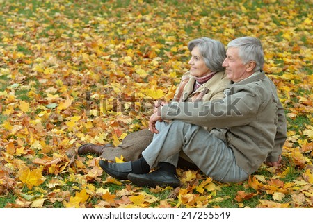 Beautiful happy old people sitting in the autumn park