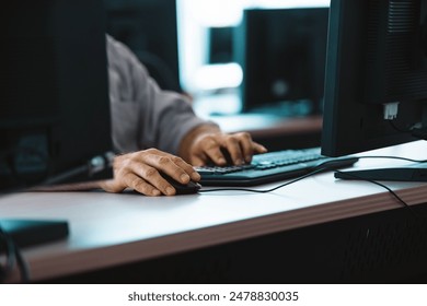 Hands typing on a keyboard and using a mouse at a busy training center, focusing on repairing hardware and troubleshooting it issues