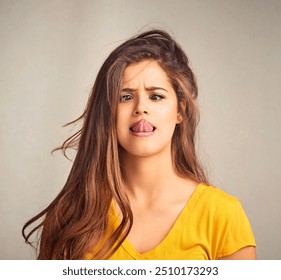 Tongue out, silly and woman in studio with emoji reaction, facial expression and crossed eyes. Comic, confident and isolated person with crazy, goofy and funny face for humor on gray background