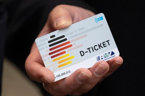 Ein Deutschlandticket in der Hand eines Mannes