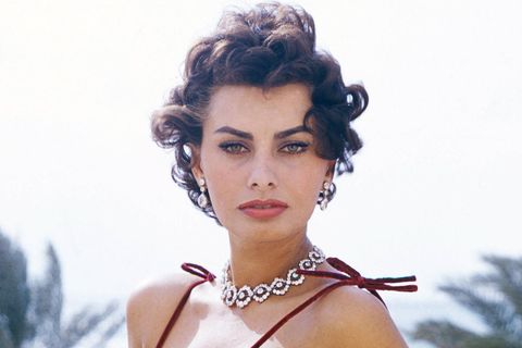 Sophia Loren in rotem Kleid, mit Edelsteinkette, blickt in die Kamera