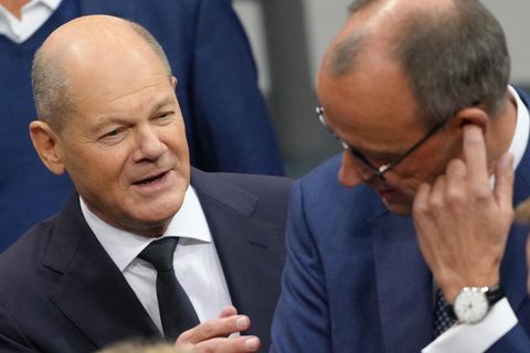 Bundeskanzler Olaf Scholz spricht im Bundestag mit Friedrich Merz