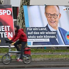 Wahlplakate von Olaf Scholz und Friedrich Merz stehen nebeneinander