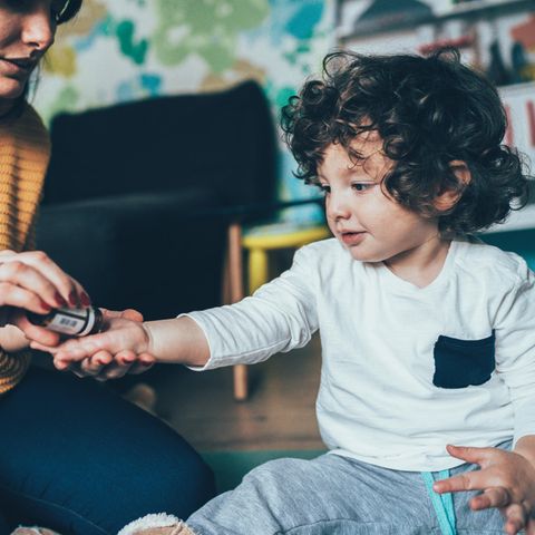 Homöopathie: Eine Frau gibt einem Jungen ein homöopathisches Mittel