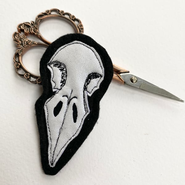 Embroidered bird skull brooch pin of badge. 