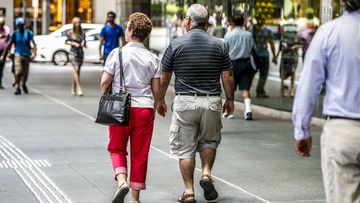 Two old people walk down the street in Brisbane