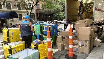 An Amazon worker sorts deliveries on a street corner on New York&#x27;s Upper West Side, Aug. 14, 2023. 