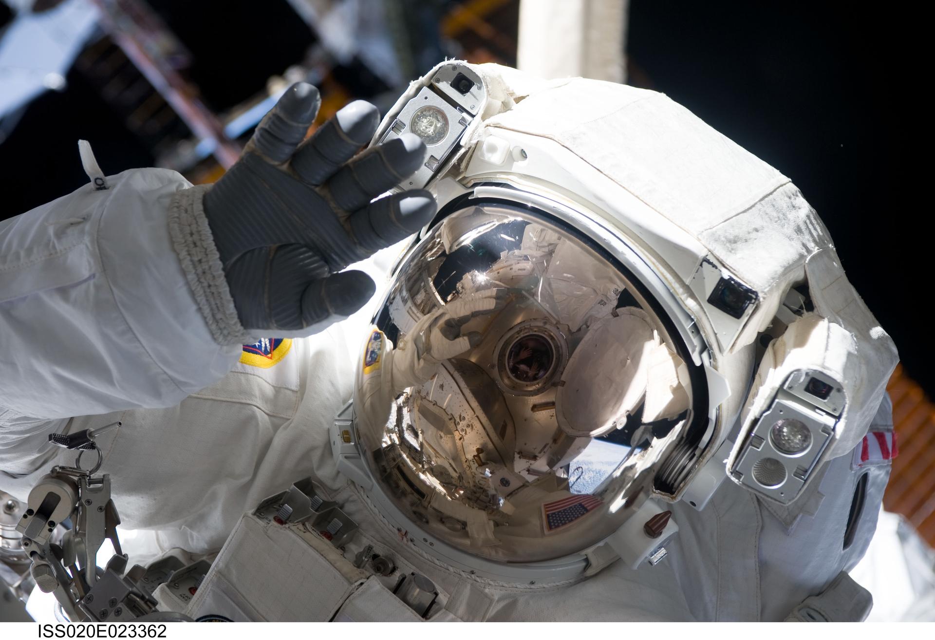 Astronaut Christopher Cassidy waves during a spacewalk on the International Space Station.