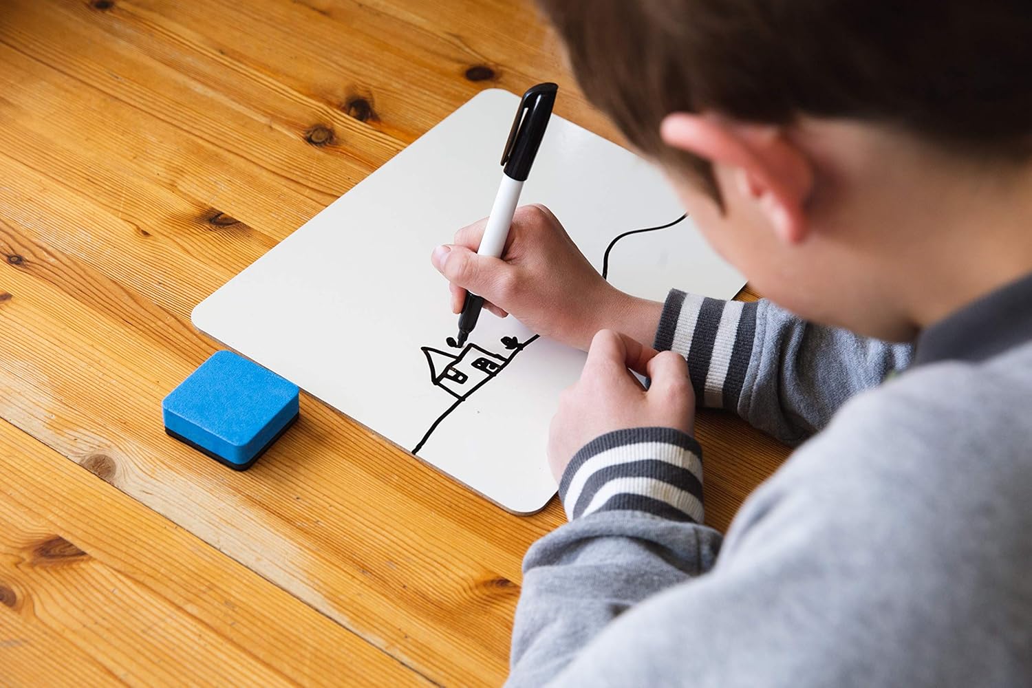 Boy writing on a personal-sized whiteboard.