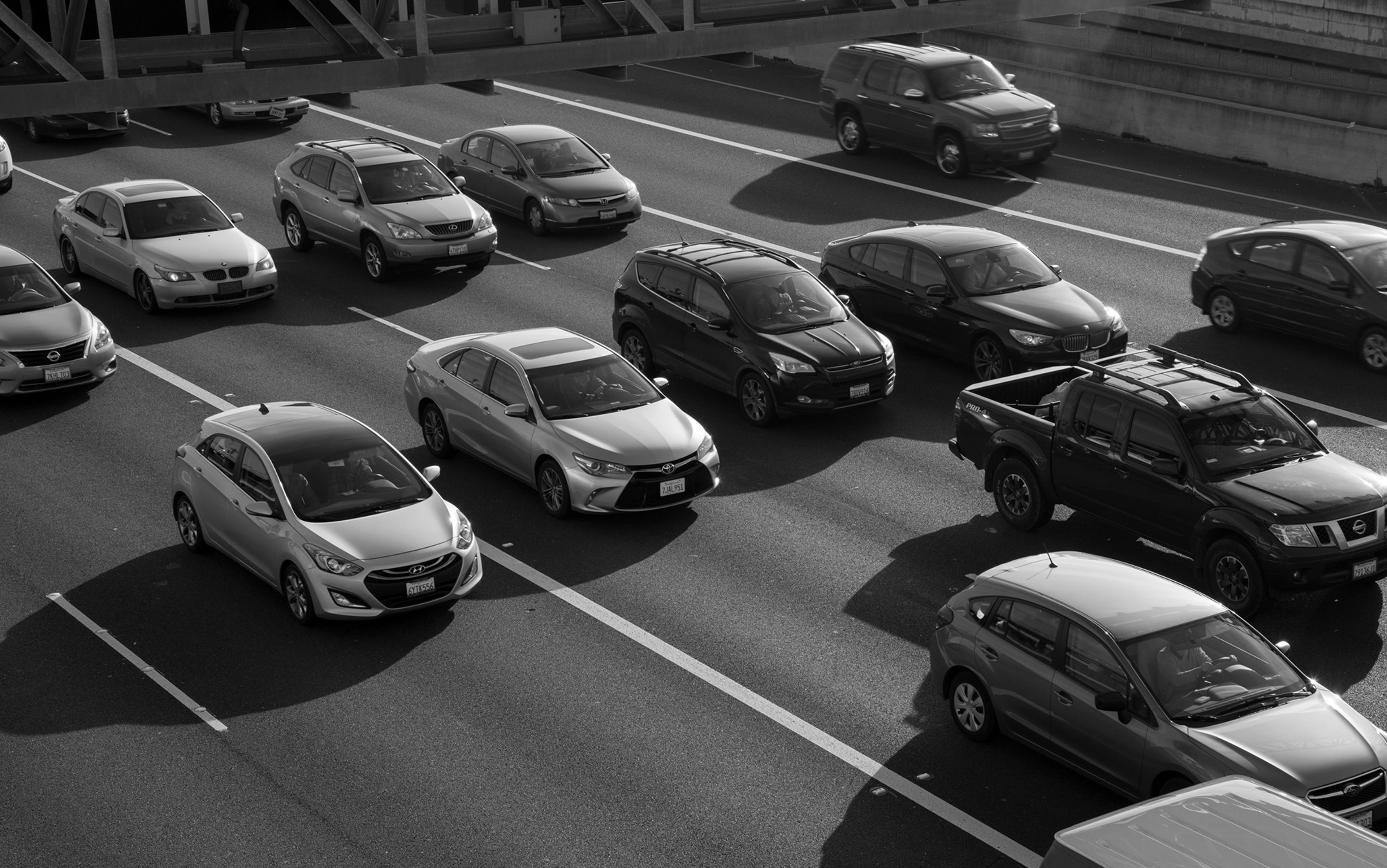 Black and white photo of cars in traffic on a multi-lane motorway seen from above.