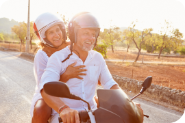 A couple riding a scooter