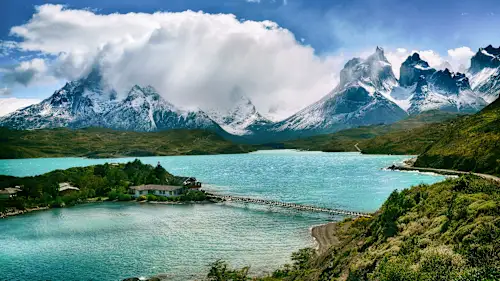 Blick auf die Bergkette und einen See mit Anlegesteg, Torres del Paine, Chile