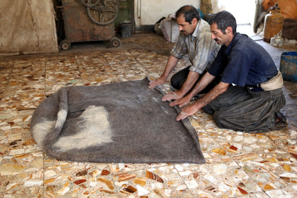 Men making felted fabric