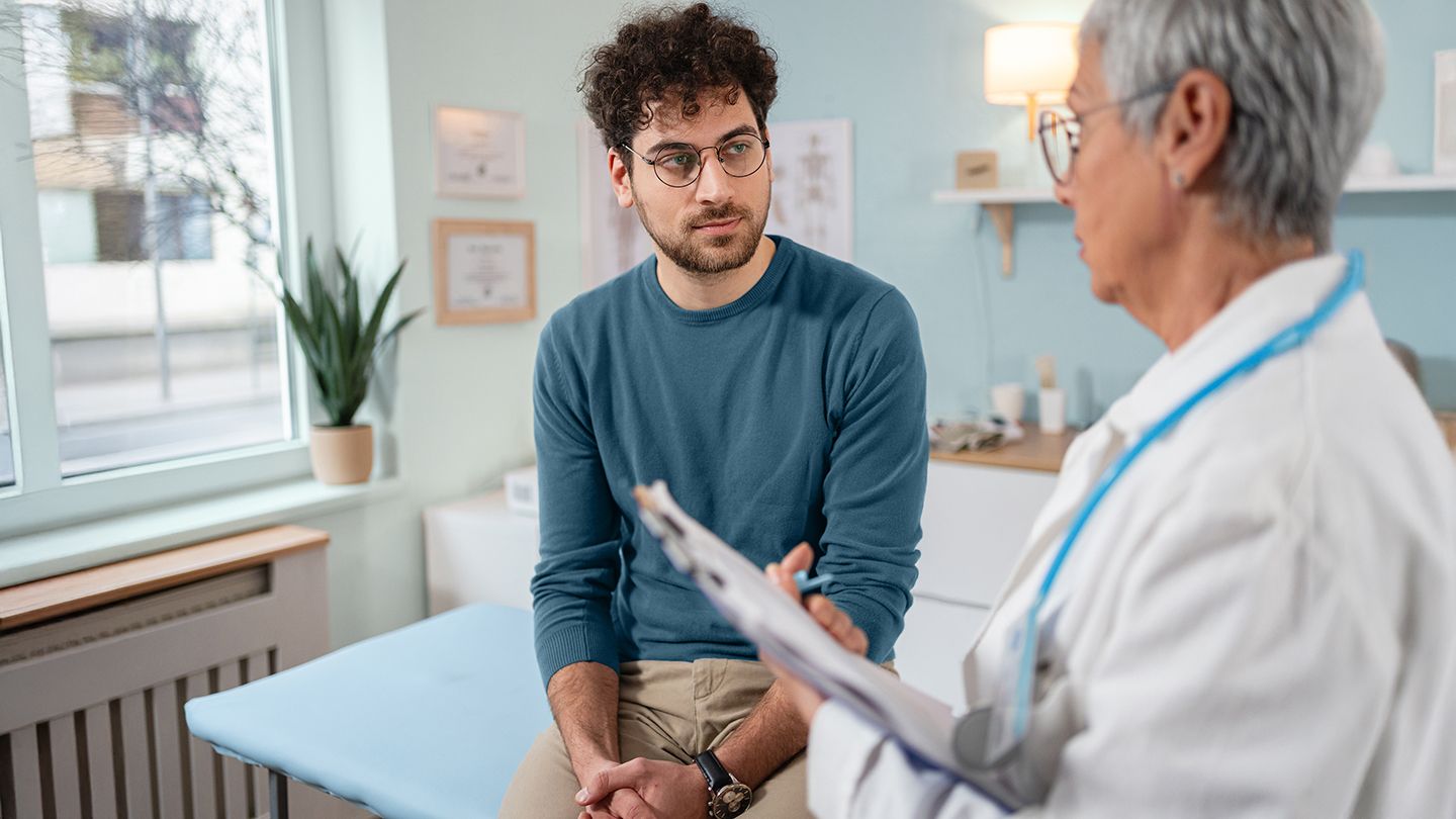 man talking with his doctor in exam room