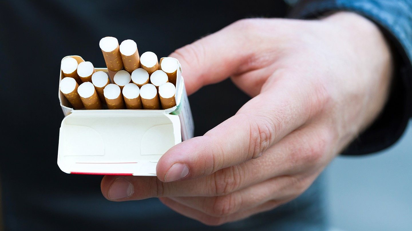 a person holding a pack of cigarettes