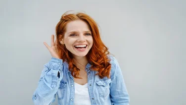 woman smiling appearing very happy with clean hearing aids