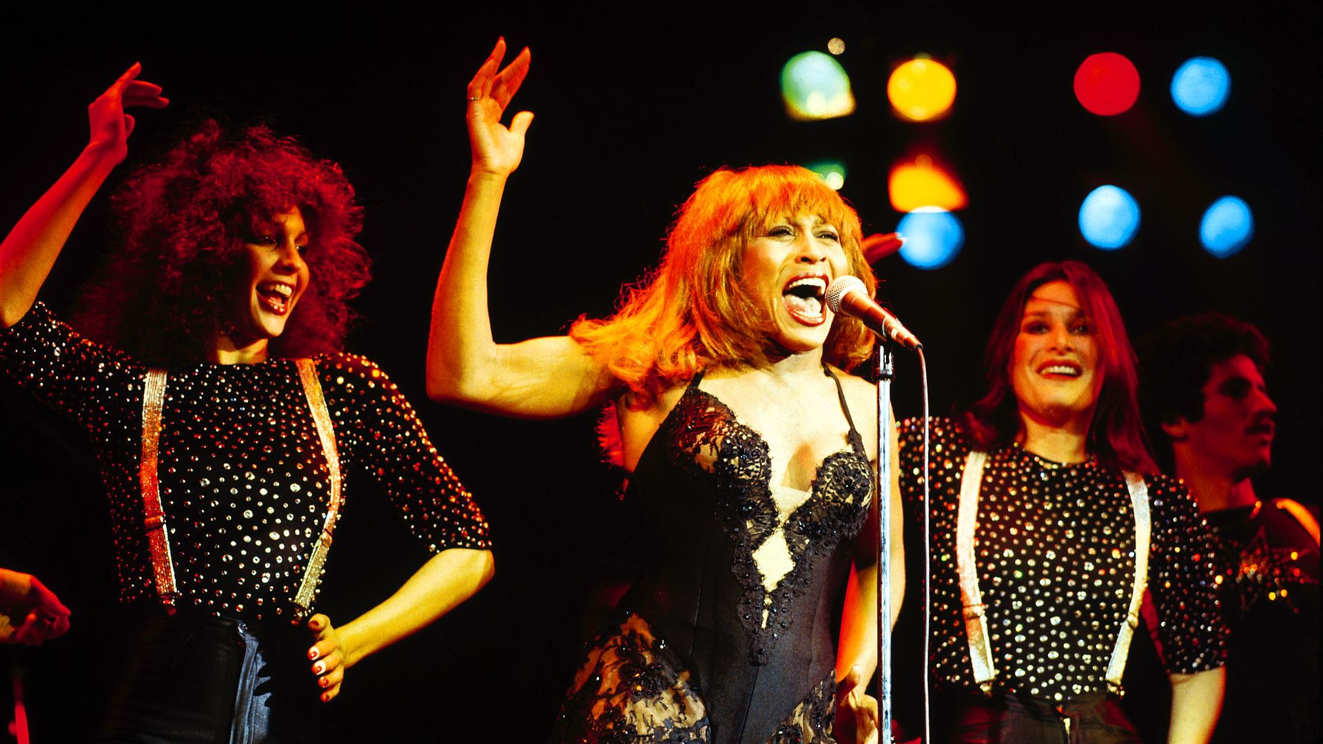 Tina Turner wearing a black lace mini dress