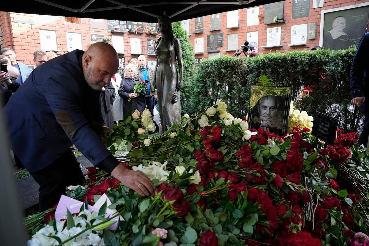 People lay flowers at the grave of former Soviet President Mikhail Gorbachev during his funeral at Novodevichy Cemetery in Moscow, Russia.